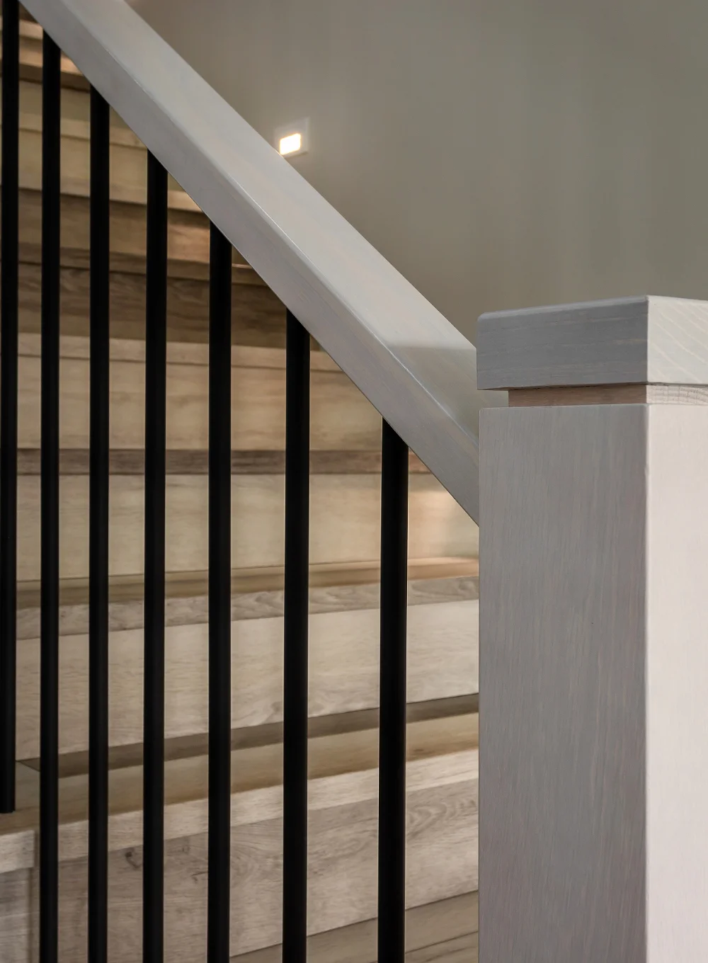 Newel post railing with black balusters, finish carpentry closeup